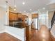 Open-concept kitchen featuring stainless steel appliances, granite countertops, wood cabinets, and hardwood flooring at 3930 Charleston Market St # 221, Suwanee, GA 30024