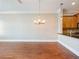 Living room featuring hardwood floors, chandelier, and open layout to the kitchen at 3930 Charleston Market St # 221, Suwanee, GA 30024