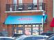 Planet Smoothie storefront with bright blue awning and outdoor seating, bustling atmosphere at 3930 Charleston Market St # 221, Suwanee, GA 30024