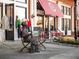 Charming street view featuring a bronze statue, storefronts, and outdoor seating in a bustling community at 3930 Charleston Market St # 221, Suwanee, GA 30024