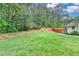 Large backyard with lush green grass and a brown wooden fence at 425 Charlyne Way, Dacula, GA 30019