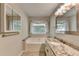 This bathroom offers a soaking tub, modern vanity and granite countertops at 425 Charlyne Way, Dacula, GA 30019