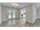 Dining room with gray wood-look flooring and access to back patio and updated kitchen at 425 Charlyne Way, Dacula, GA 30019