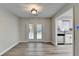 Dining room with gray wood-look flooring leads to a kitchen with white cabinetry at 425 Charlyne Way, Dacula, GA 30019