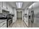 Renovated kitchen features stainless steel appliances, granite countertops, and white cabinetry at 425 Charlyne Way, Dacula, GA 30019