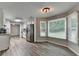A bright kitchen features white cabinets, stainless appliances, breakfast nook, and modern wood-look flooring at 425 Charlyne Way, Dacula, GA 30019