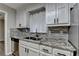Beautiful kitchen features granite countertops, white cabinets, and stainless steel appliances at 425 Charlyne Way, Dacula, GA 30019