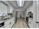Bright galley kitchen with white cabinets, stainless steel appliances, and gray backsplash at 425 Charlyne Way, Dacula, GA 30019