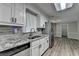 Updated kitchen with white cabinets, granite countertops, and stainless steel appliances at 425 Charlyne Way, Dacula, GA 30019