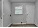 Well-lit laundry room with updated flooring, window, washer-dryer hookups, and exterior door at 425 Charlyne Way, Dacula, GA 30019