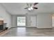 Bright living room features a brick fireplace, ceiling fan, and gray wood-look flooring at 425 Charlyne Way, Dacula, GA 30019