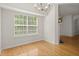 Dining area with hardwood floors, a modern chandelier, and a large window at 5686 Lawley Dr, Alpharetta, GA 30022