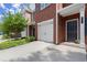 Exterior shot of a brick townhome with a one-car garage and sidewalk at 5686 Lawley Dr, Alpharetta, GA 30022