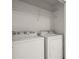 Bright laundry room featuring a white washer and dryer, and wire shelving above at 5686 Lawley Dr, Alpharetta, GA 30022