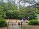 A community playground featuring swings, slides, and other play equipment, nestled among green trees at 5686 Lawley Dr, Alpharetta, GA 30022