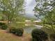 Serene view of a pond surrounded by lush trees and landscaping at 5686 Lawley Dr, Alpharetta, GA 30022