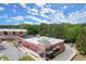 Dynamic aerial view of a shopping center featuring various retail locations with ample parking and lush surroundings at 5686 Lawley Dr, Alpharetta, GA 30022