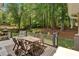 Back deck with a wood dining set and a grill, backing to a lush wooded area at 6034 Addington Nw Dr, Acworth, GA 30101