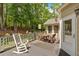 Wooden back deck with an outdoor table and chairs, surrounded by trees at 6034 Addington Nw Dr, Acworth, GA 30101