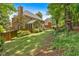Manicured backyard featuring a well-maintained lawn, mature trees, and a glimpse of the home's exterior at 6034 Addington Nw Dr, Acworth, GA 30101
