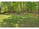 Spacious backyard with lush green grass and mature trees, perfect for outdoor enjoyment and relaxation at 6034 Addington Nw Dr, Acworth, GA 30101