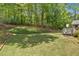 Lush backyard with mature trees and a wooden staircase leading to a raised area at 6034 Addington Nw Dr, Acworth, GA 30101