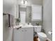 Cozy powder room with white vanity, framed mirror, and wood flooring at 6034 Addington Nw Dr, Acworth, GA 30101