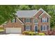Charming brick home featuring a two-car garage, classic blue shutters, and beautifully manicured landscaping at 6034 Addington Nw Dr, Acworth, GA 30101