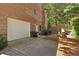 Spacious two-car garage with brick exterior, complemented by lush landscaping and a private backyard at 6034 Addington Nw Dr, Acworth, GA 30101