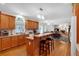 Kitchen with an island, breakfast bar, wood cabinets, and open layout to dining and living areas at 6034 Addington Nw Dr, Acworth, GA 30101