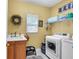 Bright laundry room with a sink, cabinetry, and modern washer and dryer units at 6034 Addington Nw Dr, Acworth, GA 30101