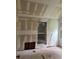 Bright bedroom with window needing renovation with drywall, exposed wood, and paint at 1946 Montrose Dr, Atlanta, GA 30344
