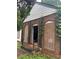 Brick home exterior with boarded up windows and wrought iron railing leading to the entrance at 1946 Montrose Dr, Atlanta, GA 30344