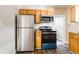 Functional kitchen with stainless steel appliances, wood cabinets, and laminate floors at 2497 Lakewood Sw Ave, Atlanta, GA 30315