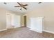 Inviting living room featuring a white fireplace, ceiling fan, and neutral carpet at 2497 Lakewood Sw Ave, Atlanta, GA 30315
