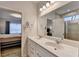 Bathroom featuring a double vanity with a mirror and tiled shower, complemented by neutral tones and modern fixtures at 5452 Fountainhead Ln, Auburn, GA 30011