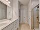 Bright bathroom with a double vanity, large mirror, and tiled shower, offering a modern and comfortable experience at 5452 Fountainhead Ln, Auburn, GA 30011