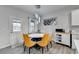 Bright dining area features modern lighting, a round table, and stylish yellow upholstered chairs at 5452 Fountainhead Ln, Auburn, GA 30011