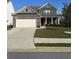 Charming two-story home featuring a gray brick facade, well-manicured lawn, and a two-car garage at 5452 Fountainhead Ln, Auburn, GA 30011