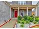 Inviting front porch with a bright red door, lovely landscaping, and a cozy seating area at 5452 Fountainhead Ln, Auburn, GA 30011