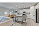 Modern kitchen with white cabinets, a large center island, stainless steel appliances, and wood floors at 5452 Fountainhead Ln, Auburn, GA 30011