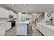 Open-concept kitchen featuring white cabinets, stainless appliances, and an island with breakfast bar seating at 5452 Fountainhead Ln, Auburn, GA 30011