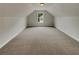 Unfinished attic featuring neutral carpet, a window and potential for storage or additional living space at 6405 Beaver Creek Trl, Atlanta, GA 30349