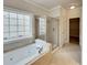 Bathroom featuring a soaking tub, separate shower, and a large window at 6405 Beaver Creek Trl, Atlanta, GA 30349