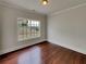 Bedroom with dark hardwood floors, large window for natural light and view of the backyard at 6405 Beaver Creek Trl, Atlanta, GA 30349