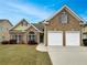 Charming brick and siding home featuring a two-car garage, well-kept lawn, and colorful landscaping at 6405 Beaver Creek Trl, Atlanta, GA 30349