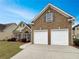 Charming brick and siding home featuring a two-car garage, well-kept lawn, and colorful landscaping at 6405 Beaver Creek Trl, Atlanta, GA 30349