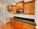 Well-lit kitchen featuring wooden cabinets, granite countertops and stainless steel microwave at 6405 Beaver Creek Trl, Atlanta, GA 30349