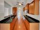 Galley kitchen with granite countertops, wood cabinets, stainless steel appliances, and hardwood floors at 6405 Beaver Creek Trl, Atlanta, GA 30349