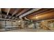 Large unfinished basement offers concrete floor, concrete walls, exposed wood ceiling, and shelving at 9588 Poston Rd, Jonesboro, GA 30238